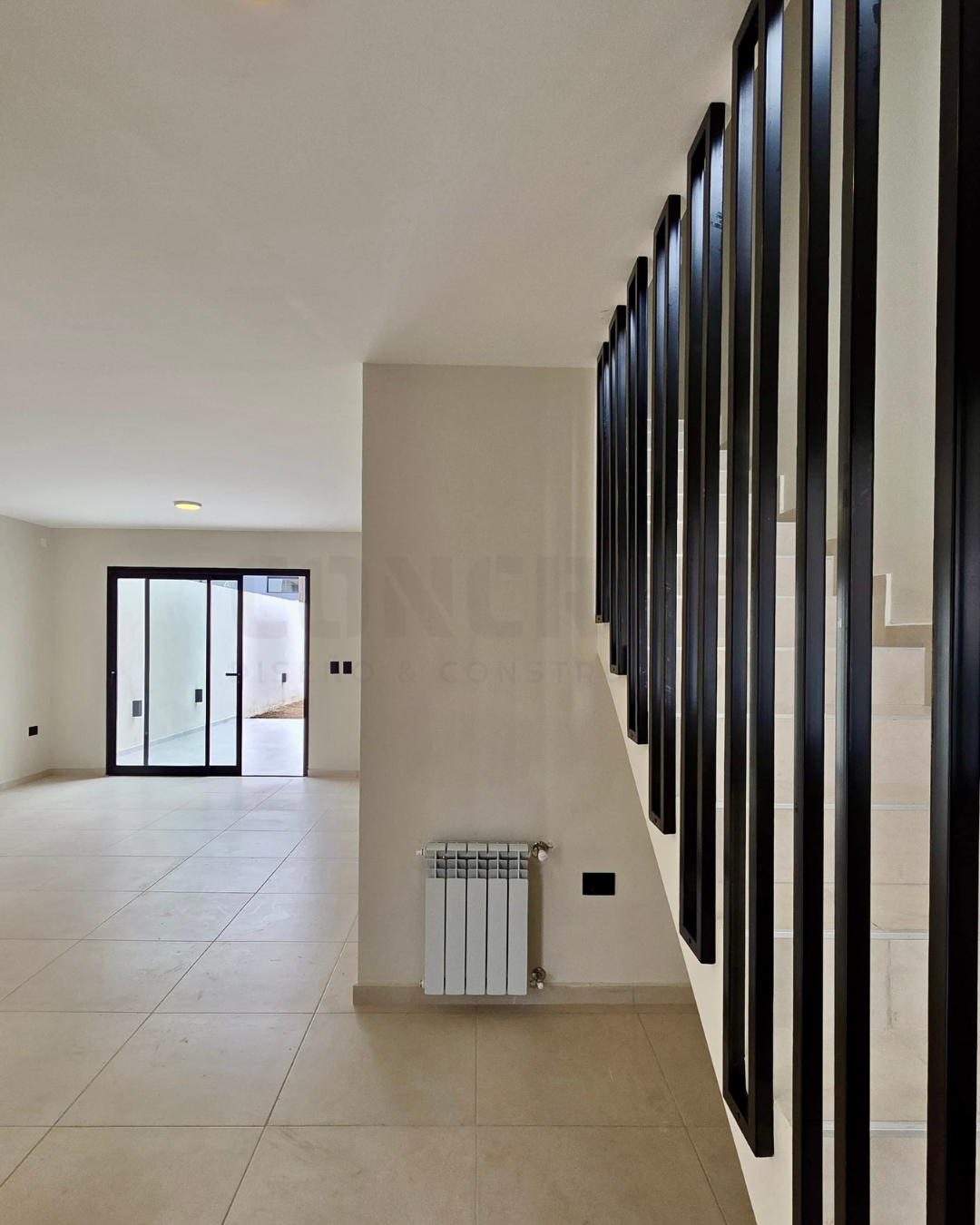 AM2 Estar comedor de AM2 con escalera y ventanales al patio.