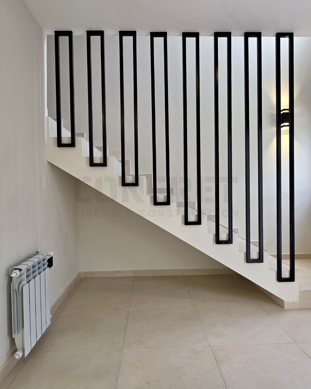 9. AM2 7 Escalera interior de AM2 con barandas metálicas negras.
